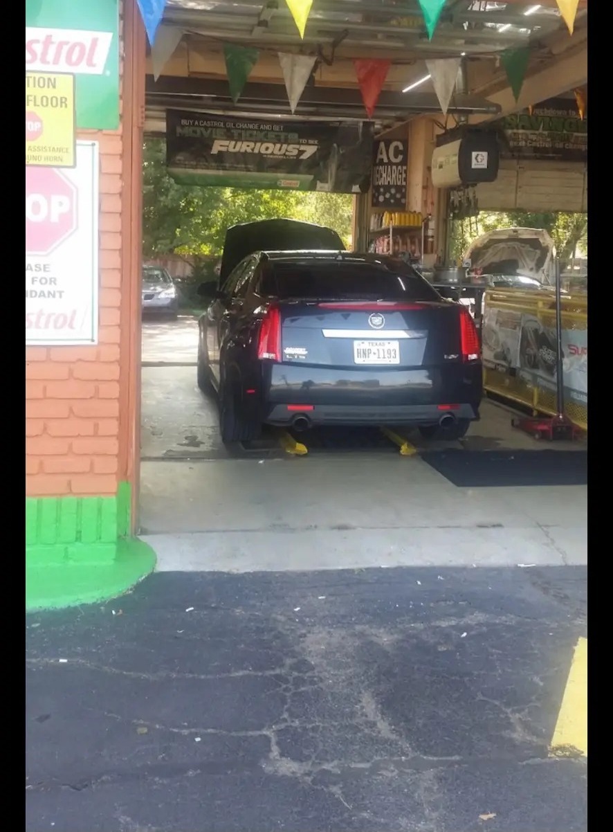 A car pulled into the service bay under the shop's banners