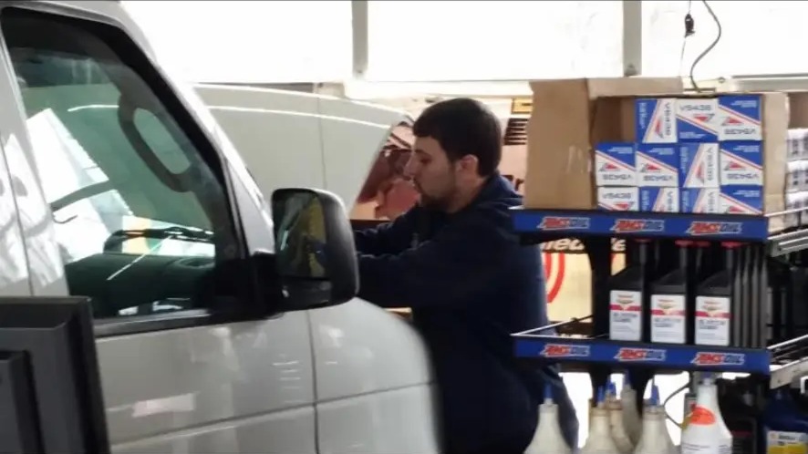 Technician servicing a work van in the bay