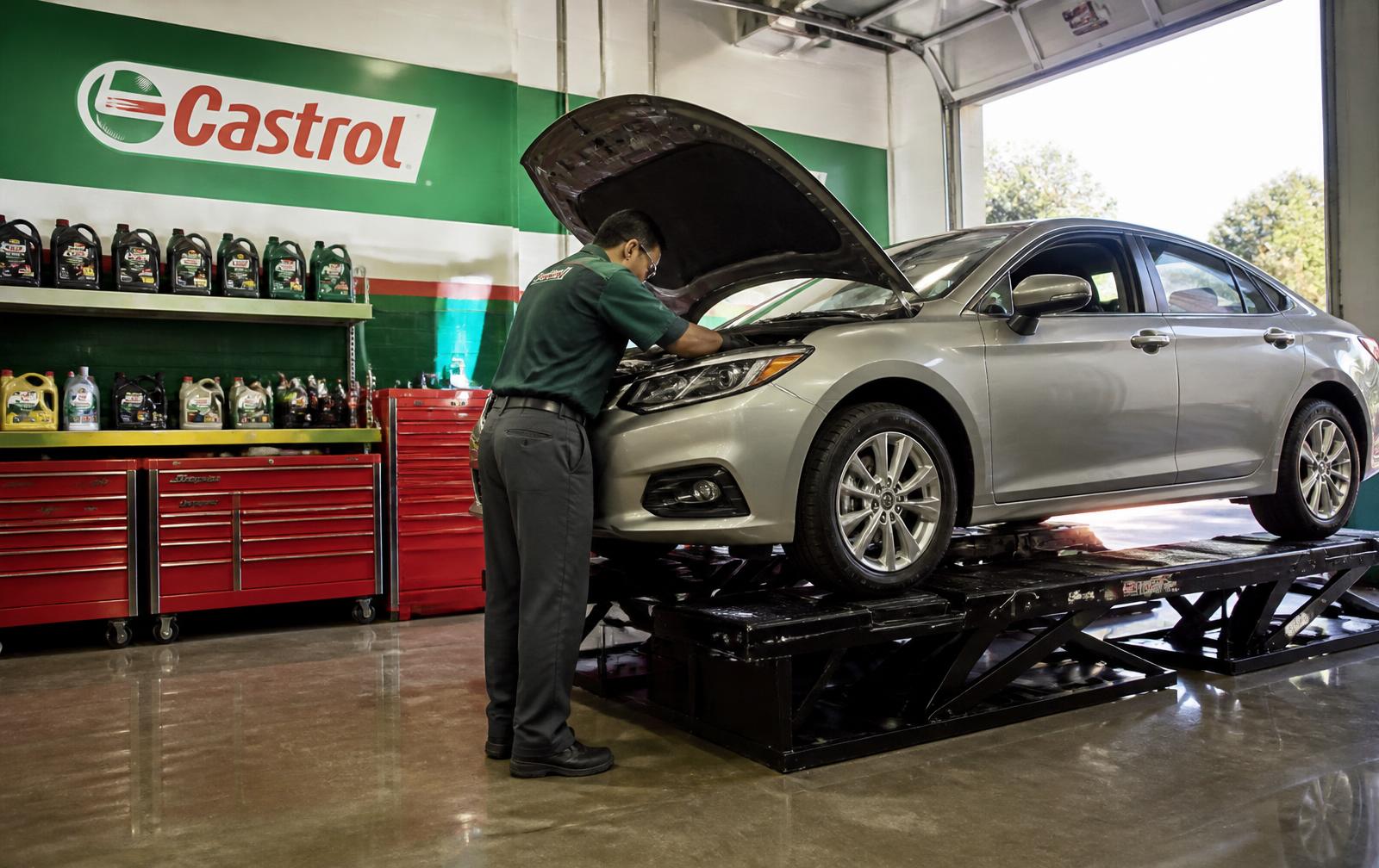 Mechanic servicing a sedan on the lift in the Castrol bay